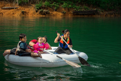 People sitting on boat in lake