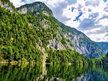 Scenic view of lake by trees against sky