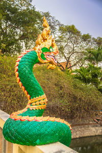 Low angle view of statue against trees and plants