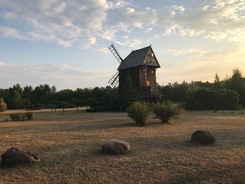 Traditional windmill on field against sky