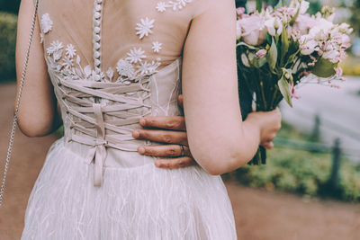 Midsection of woman holding flower bouquet