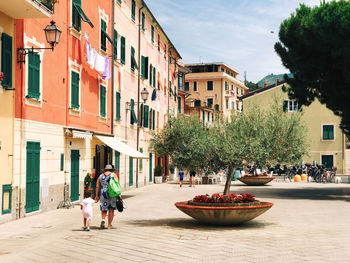 People walking on street amidst buildings in city