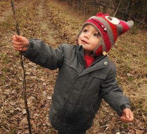 Girl holding stick while standing on field