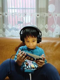 Portrait of young woman sitting on sofa at home