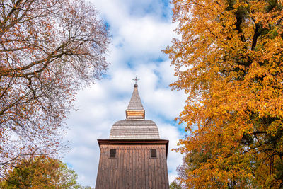The tower of the historic church made of wood. the church is covered with shingles. autumn. 