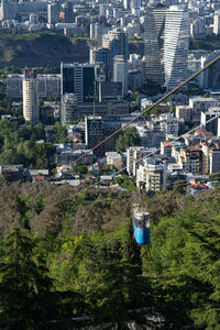 Aerial view of tbilisi town from mountain, georgia. old blue cable car cabin above the town.