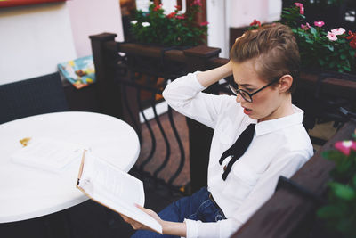 High angle view of businesswoman reading book at cafe