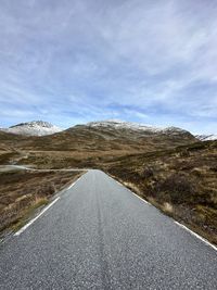 Scenic view of rural road against sky