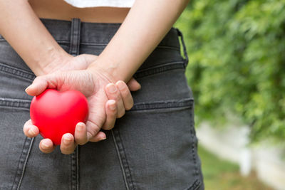 Midsection of woman holding red outdoors