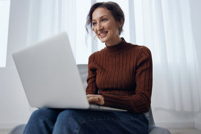 Young woman using laptop at home