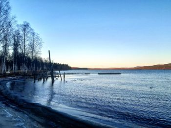 Scenic view of frozen lake against clear blue sky