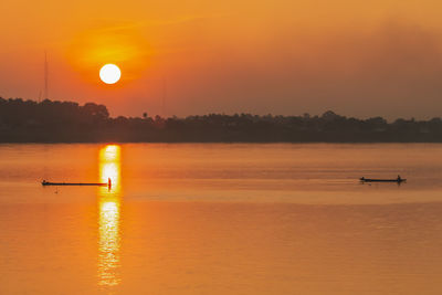 Scenic view of lake against orange sky during sunset