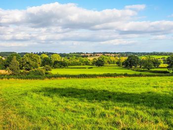 Scenic view of field against cloudy sky