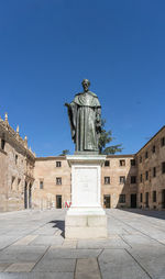 Statue of historic building against blue sky