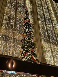 Low angle view of illuminated christmas decoration against sky at night