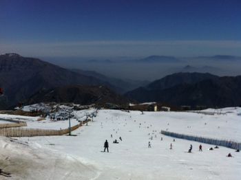 People on snow covered mountains against sky