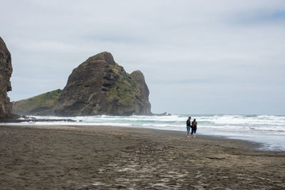 People on beach against sky