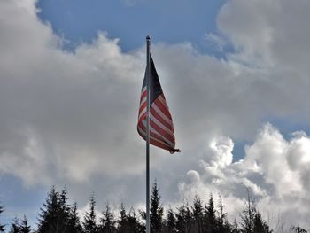 Low angle view of american flag against cloudy sky