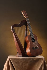 Close-up of guitar on table against wall