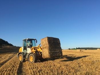 Tractor on field against clear sky