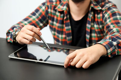 Midsection of man using digital tablet