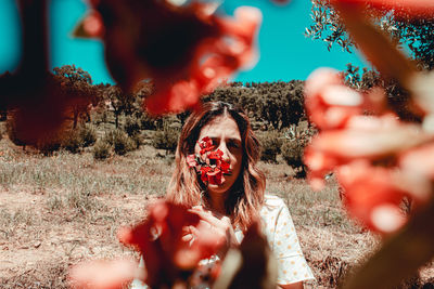 Portrait of woman holding red flowers