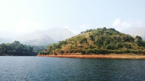 Scenic view of river and mountains against sky