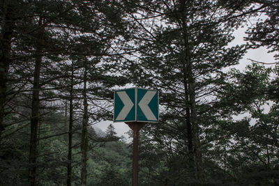 Low angle view of road sign against trees