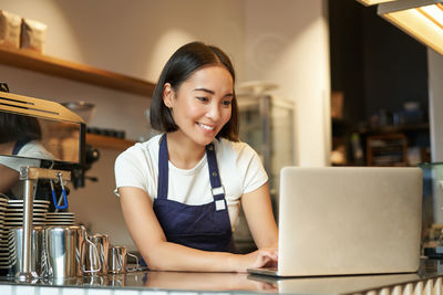 Young woman using laptop at table