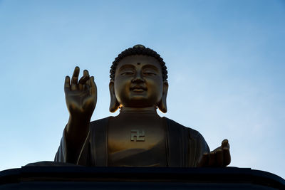 Low angle view of buddha statue against clear sky