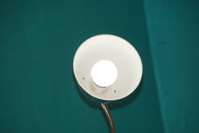 Close-up of illuminated electric lamp against wall