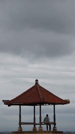 Lifeguard hut against cloudy sky