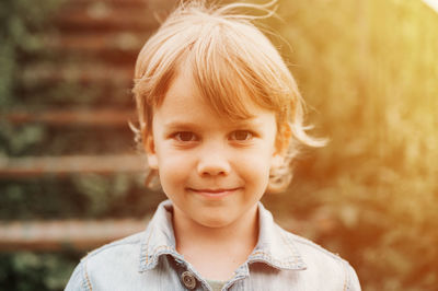 Portrait of face of a cute happy smiling little five year old long blond or homeschooler kid boy