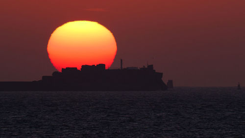 Scenic view of sea against orange sky