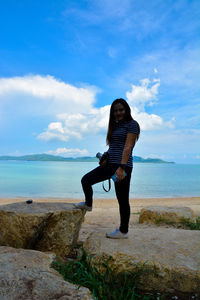 Full length of woman on beach against sky