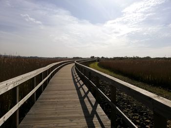 View of walkway on field against sky