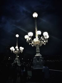 Low angle view of illuminated chandelier against sky at night