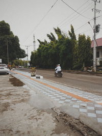 Man on street against sky in city