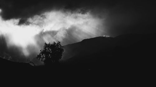 Silhouette of mountain against cloudy sky