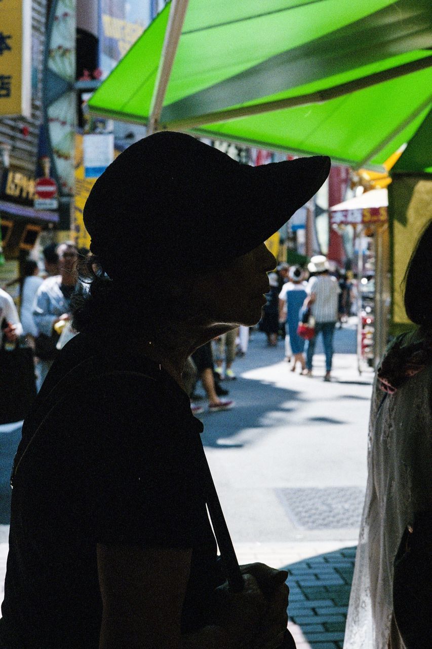 city, focus on foreground, lifestyles, incidental people, city life, leisure activity, day, outdoors, close-up, market stall, casual clothing, city street