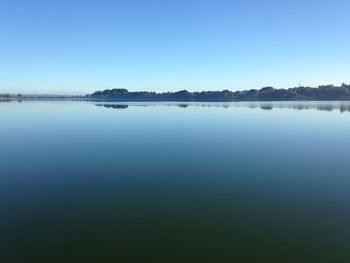 Calm lake against clear sky