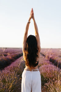 Brunette woman on her back stretching her in lavender field