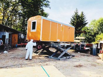 Rear view of man working against orange sky