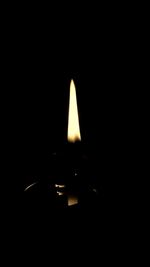 Close-up of lit candle in darkroom