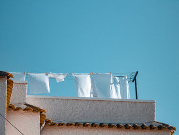 Low angle view of clothes drying against blue sky