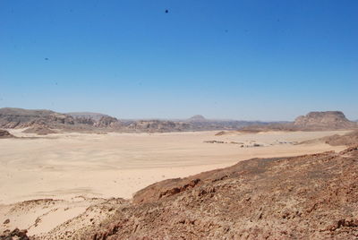 Scenic view of desert against clear blue sky