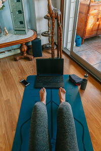 Low section of man using laptop on table at home