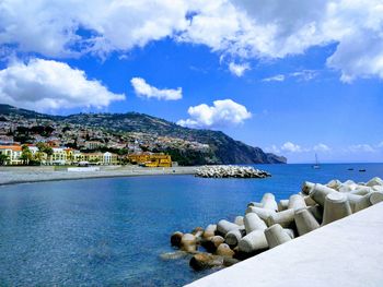 Scenic view of sea by buildings against sky