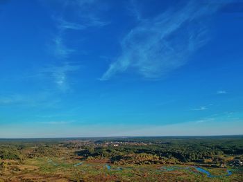 Scenic view of field against blue sky