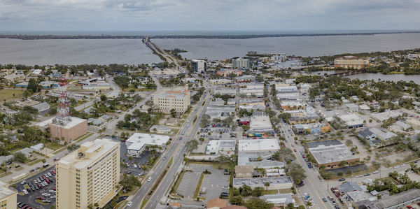 High angle view of townscape by sea against sky